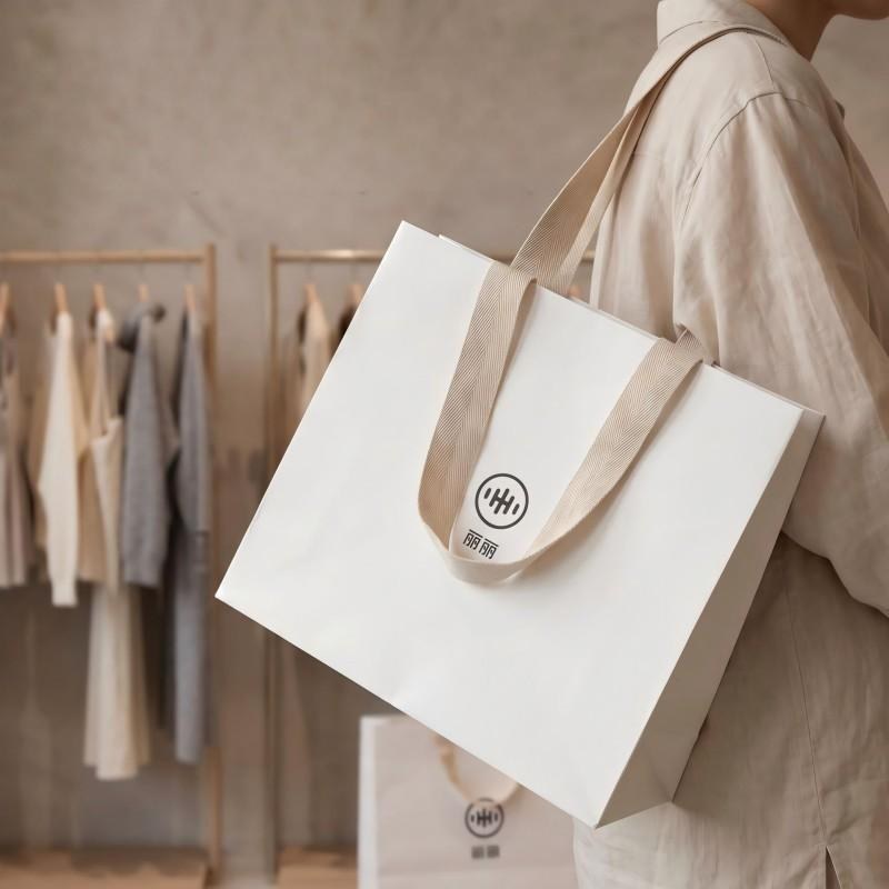 White luxury paper bag carried in a boutique